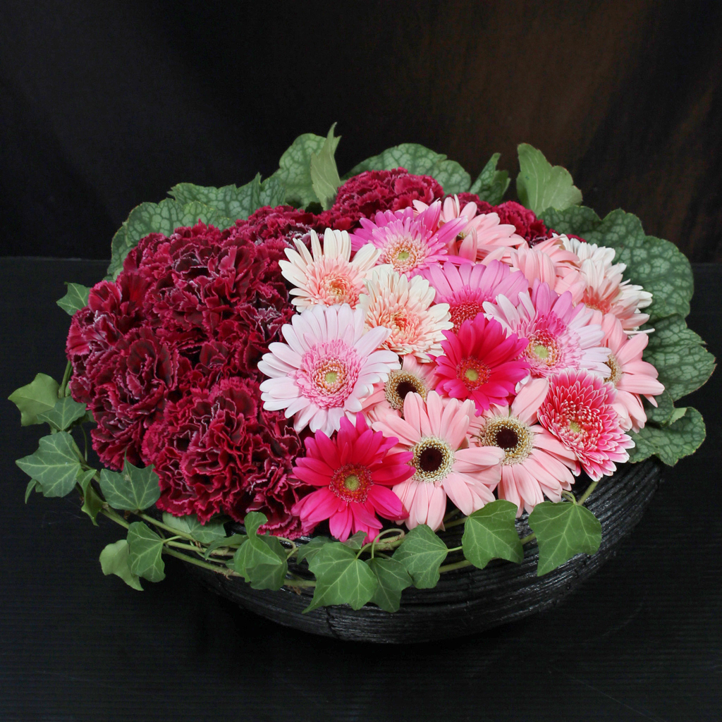 ピンクのガーベラとシックなカーネーションを合わせた、優しく華やかなハッピーバスケット（ピンク）