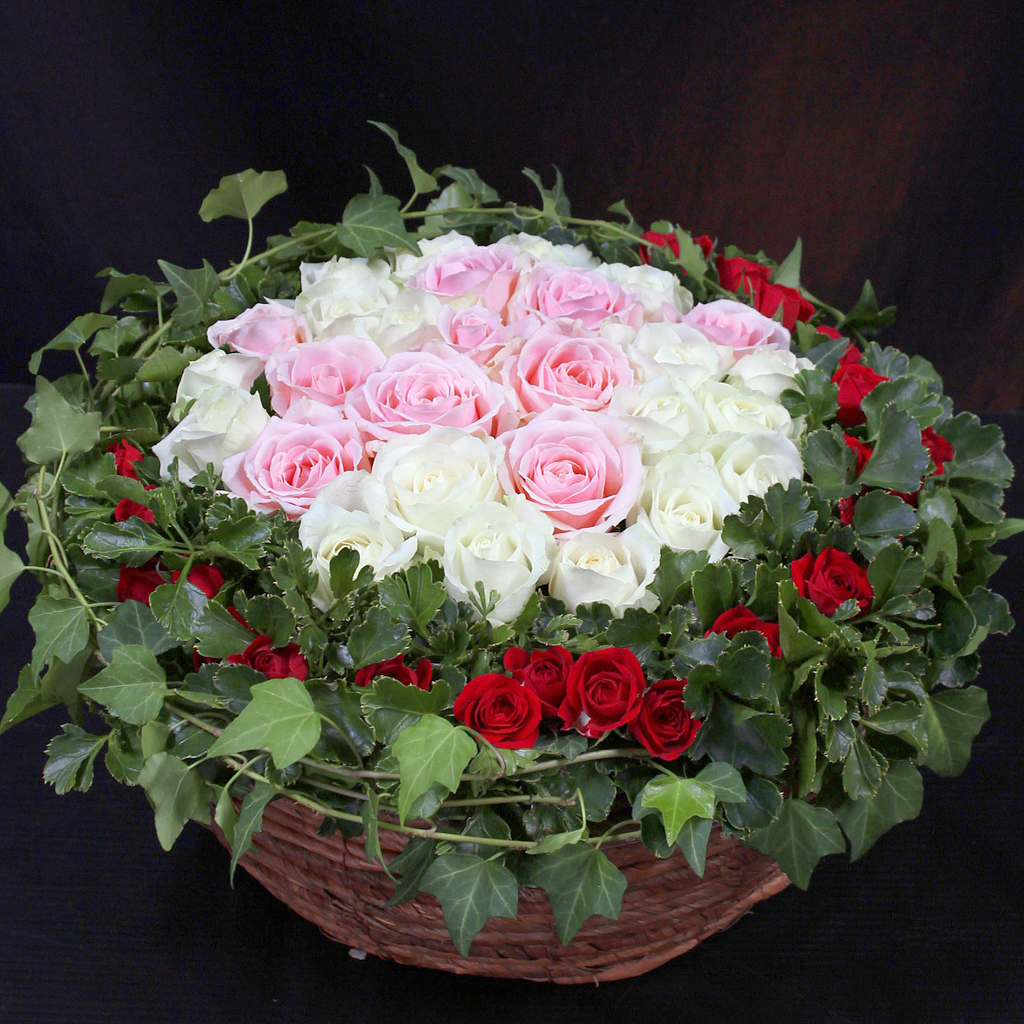 白とピンクのバラを中心に、赤いバラと深い緑で縁取られた華やかなアレンジメント ラブリーローズ