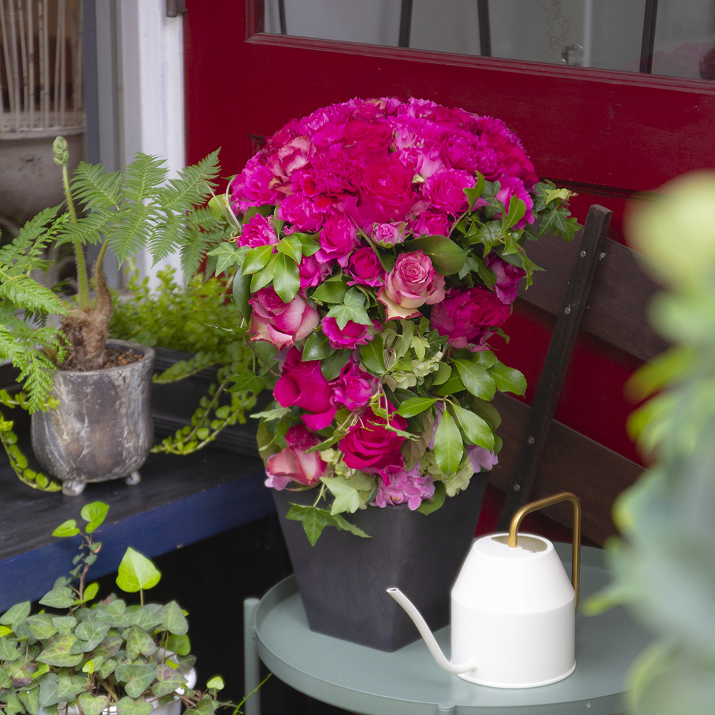 生き生きとしたピンクの花々が空間を明るく彩る、上品なデザイナーズフラワーの設置イメージ