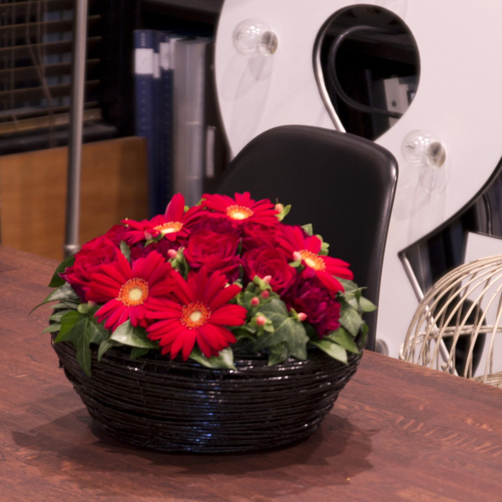 情熱的な赤と鮮やかなグリーンが織りなすモダンなフラワーデザインの近景