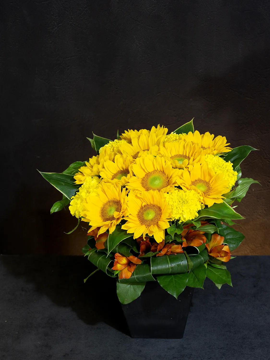 太陽のように明るいヒマワリとイエロー・オレンジの花々を合わせたアレンジメント「サニー・ハーモニー」。
誕生日・記念日祝い・楽屋見舞い・お祝いなど、想いをきちんと届けたいシーンにおすすめです。
全国配送に対応し、遠方の方にも季節の花の魅力をお届けできます。