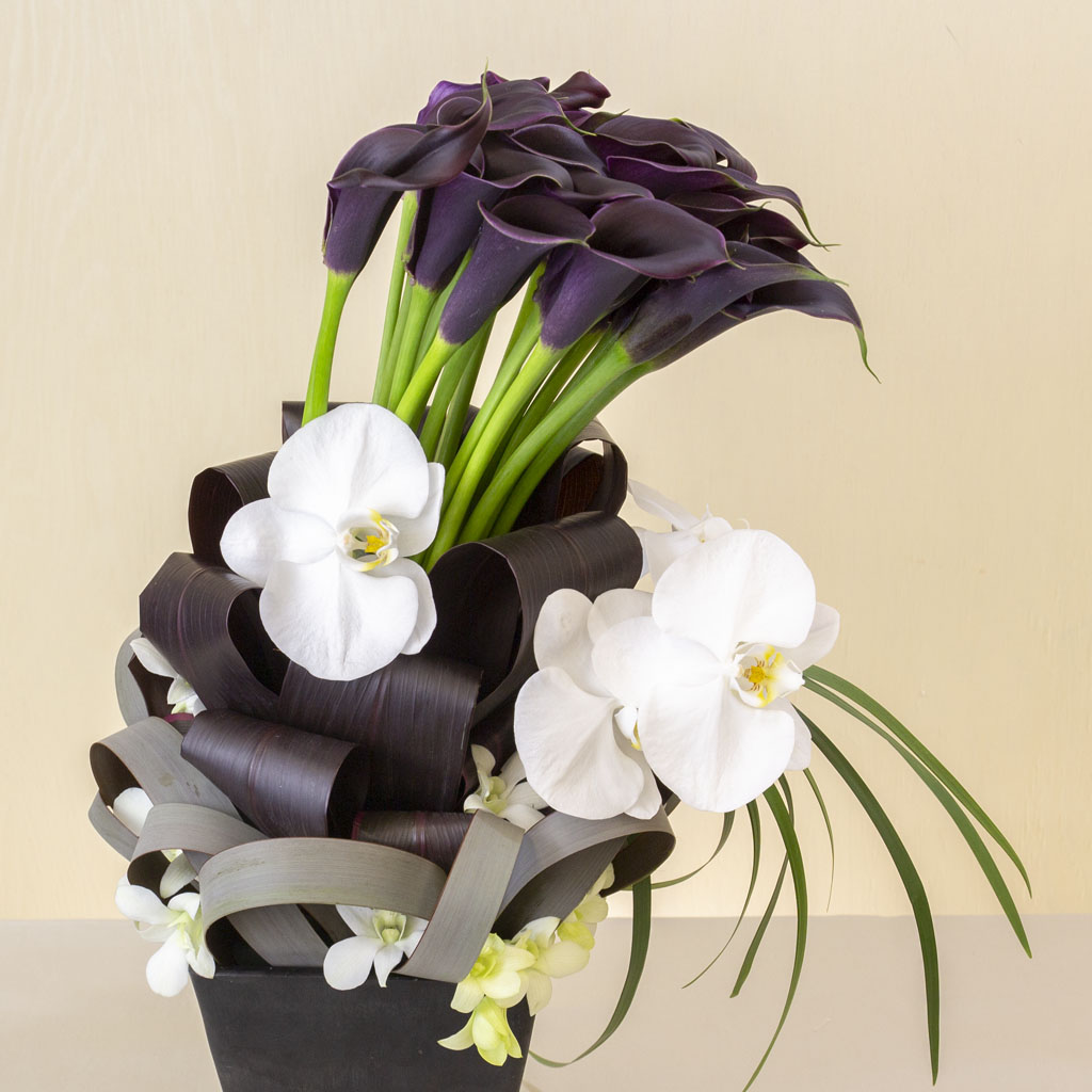 黒色のカラーと蘭を贅沢に使用した、洗練されたフォルムのモダンなフラワーアレンジメント『カラーシャルム』