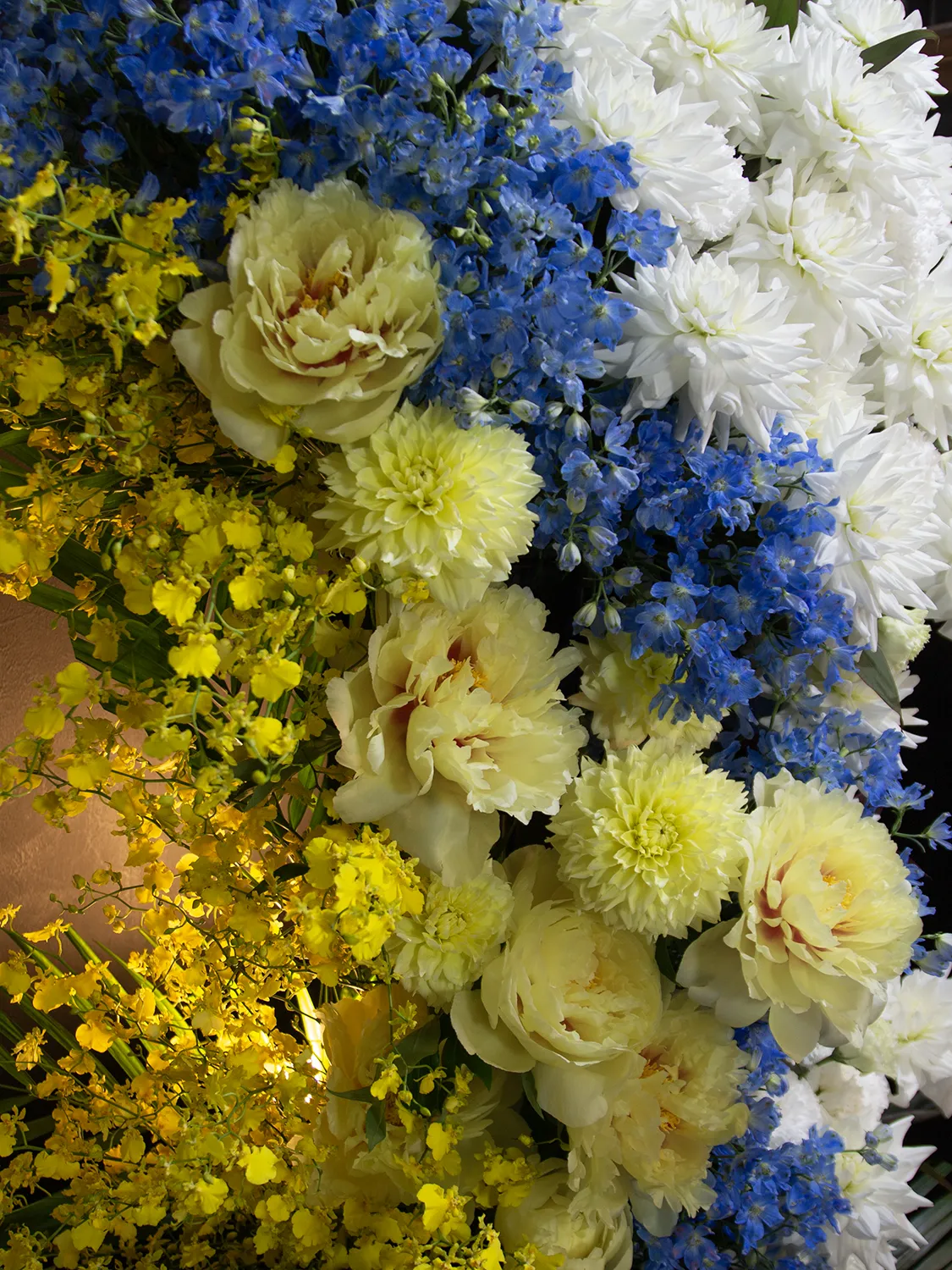 開店祝い・開業祝い・ライブ祝いに美しい立体感を与える、白・青・黄色のお花と流麗なグリーンの調和が美しいアップショット